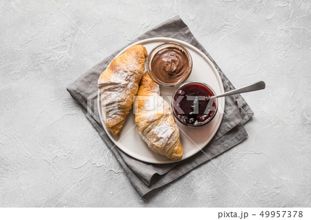 Freshly baked croissants with berry jam on gray. 49957378