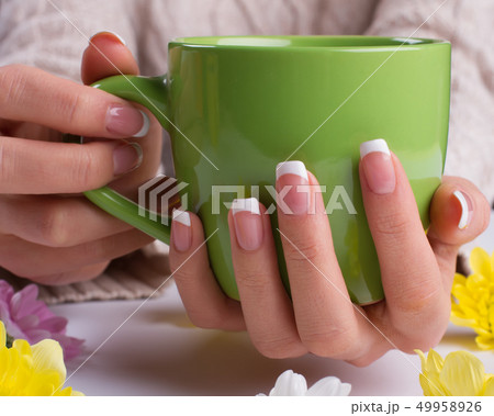 Female hands holding a mug. Female hands holding a mug. 49958926
