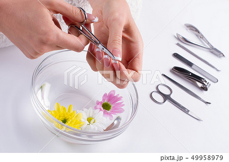 Girl cuts off the cuticle nail scissors. 49958979