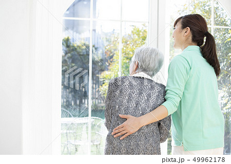 立つ高齢者を支えるヘルパー 49962178