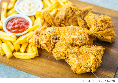 Fried chicken wings with french fries and tomato or ketchup and mayonnaise sauce Fried chicken wings with french fries and tomato or ketchup and mayonnaise sauce 49968296