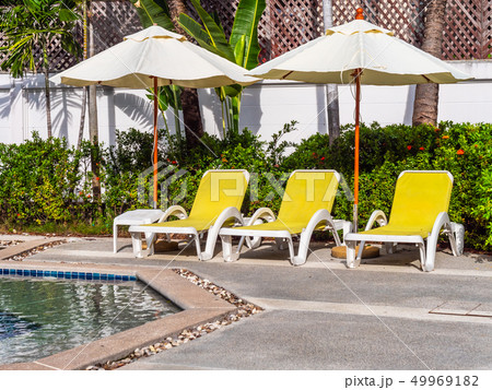 Umbrella and chair around luxury outdoor swimming pool 49969182