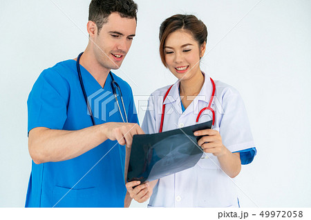 Doctors working with x ray film of patient head. Doctors working with x ray film of patient head. 49972058