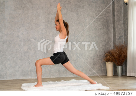 Young woman yoga on carpet at home living room. 49972257