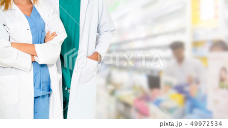 Pharmacist working with colleague in pharmacy. 49972534