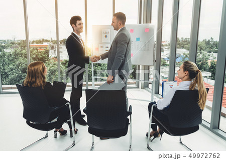 Businesswomen and businessmen in group meeting. 49972762