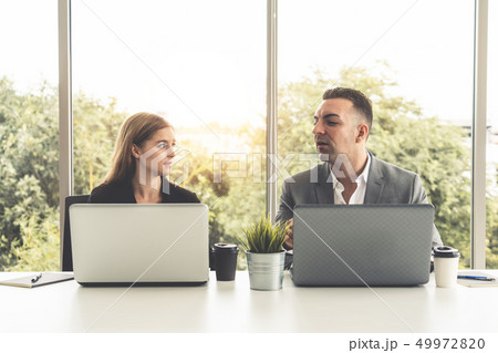 Businessman and businesswoman working in office. 49972820