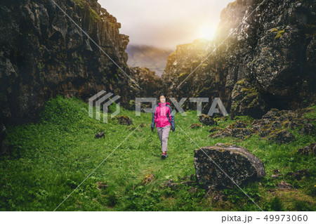 Woman traveler hiking across Iceland landscape. Woman traveler hiking across Iceland landscape. 49973060