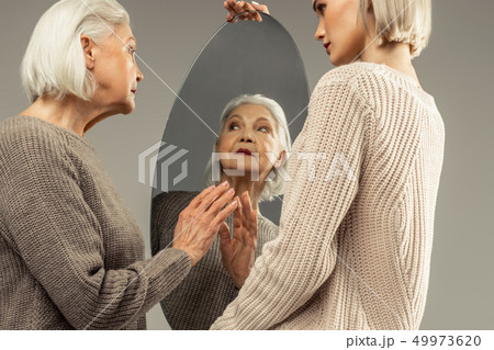 Pleasant nice elderly woman looking at herself 49973620