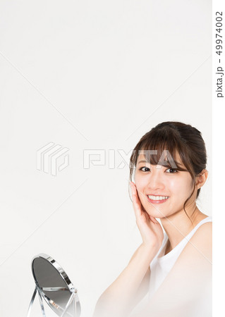 鏡を見る若い女性 ビューティー 49974002