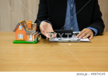 realtor agent with house model & home key. buying renting real estate property 49974145
