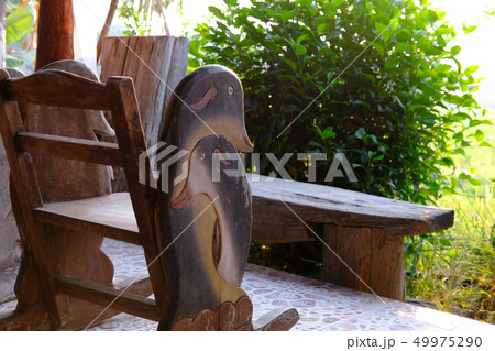 wooden chair table on cozy terrace with garden view 49975290