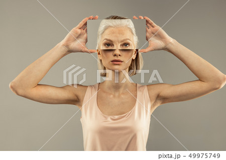 Nice pretty young woman holding a mirror Nice pretty young woman holding a mirror 49975749