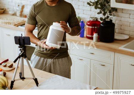 Man holding big pack of dietary protein for sportsmen Man holding big pack of dietary protein for sportsmen 49975927
