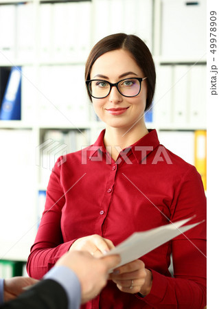 Smiling beautiful businesswoman wear glasses hold in arms financial papers Smiling beautiful businesswoman wear glasses hold in arms financial papers 49978909