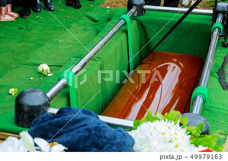 Burying a coffin at cemetery during a funeral Burying a coffin at cemetery during a funeral 49979163