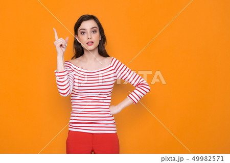 Waist up of serious brunette lady posing for camera in studio 49982571