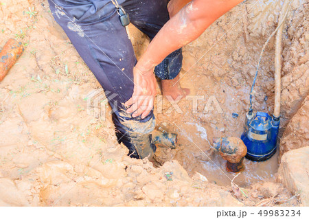 male plumber are repair broken pipe in hole  49983234