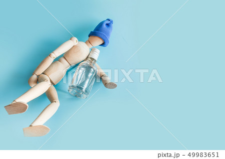 Wooden doll with bottle of vodka on blue.  49983651