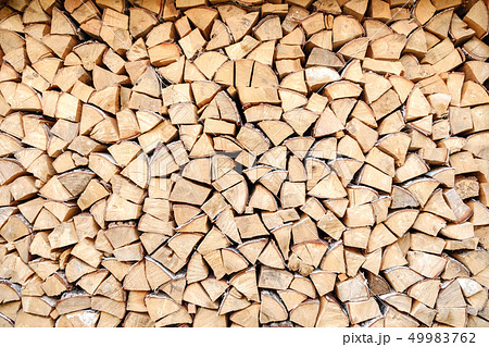 Background of chopped, sawn and stabbed stacked wooden logs. 49983762