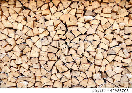 Background of chopped, sawn and stabbed stacked wooden logs. 49983763