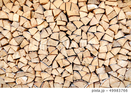 Background of chopped, sawn and stabbed stacked wooden logs. 49983766