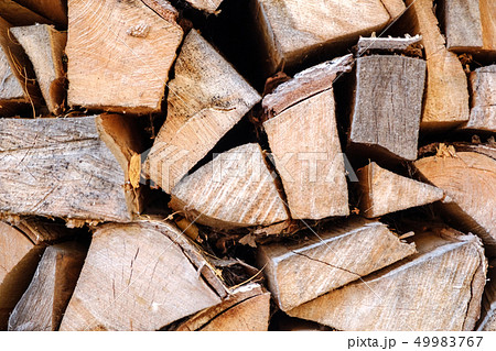 Background of chopped, sawn and stabbed stacked wooden logs. 49983767