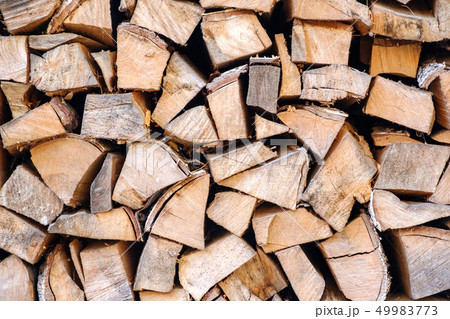 Background of chopped, sawn and stabbed stacked wooden logs. 49983773