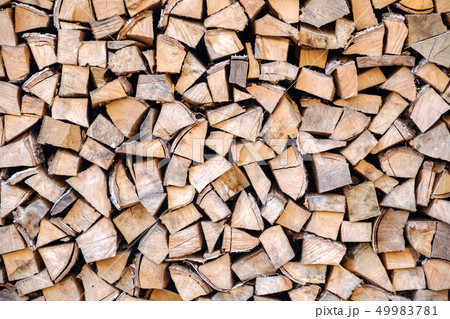 Background of chopped, sawn and stabbed stacked wooden logs. 49983781