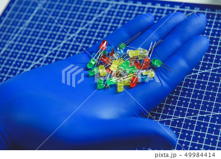 Engineer holding colorful RGB light-emitting diodes in arms Engineer holding colorful RGB light-emitting diodes in arms 49984414