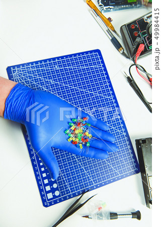 Engineer holding colorful RGB light-emitting diodes in arms 49984415