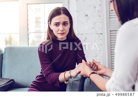 Upset crying scared attractive lady being comforted by a therapist Upset crying scared attractive lady being comforted by a therapist 49986587