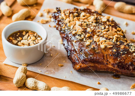 Close up board with pork ribs grilled with BBQ sauce and peanuts Close up board with pork ribs grilled with BBQ sauce and peanuts 49986677