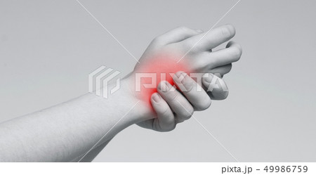 Young woman rubbing her inflamed back of hand Young woman rubbing her inflamed back of hand 49986759