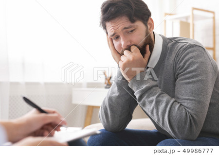 Millennial man with depression during psychotherapy session 49986777