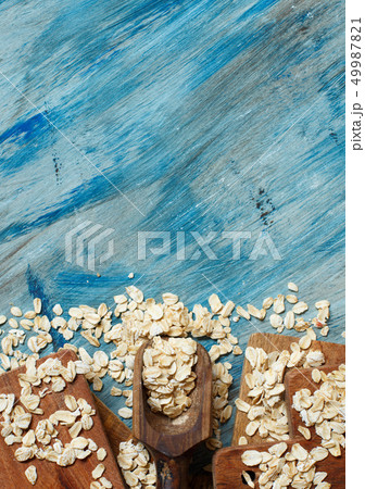 Rolled oats with a wooden spoon top view 49987821