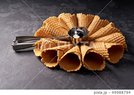 Waffle cones for ice cream and a spoon for it on 49988794
