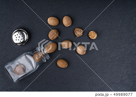 Nutmeg scattered on a black stone background 49989077