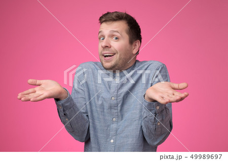 guy showing I have no idea gesture, shrugging shoulders and raising hands 49989697