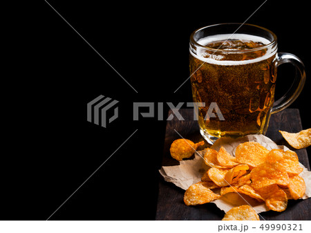 Glass of lager beer with potato crisps snack on Glass of lager beer with potato crisps snack on 49990321