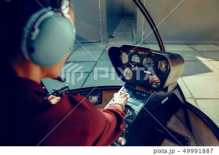 Resolute experienced female pilot observing information on dashboard 49991887