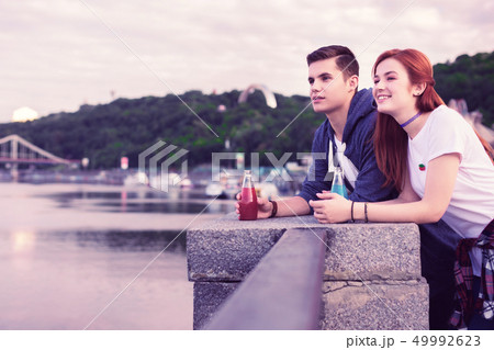 Inspired dark-haired guy looking on the river view while staying with girl 49992623