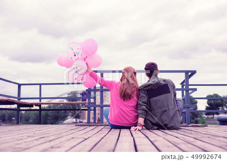 Lovely good-looking young couple spending time together on the wooden pier 49992674