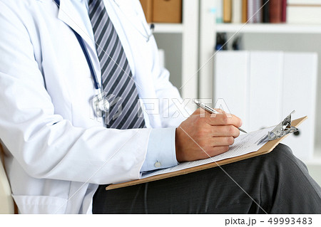 Male medicine doctor hand holding silver pen writing Male medicine doctor hand holding silver pen writing 49993483
