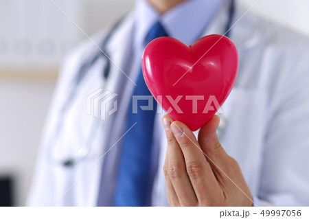 Male medicine doctor hands holding red toy heart Male medicine doctor hands holding red toy heart 49997056