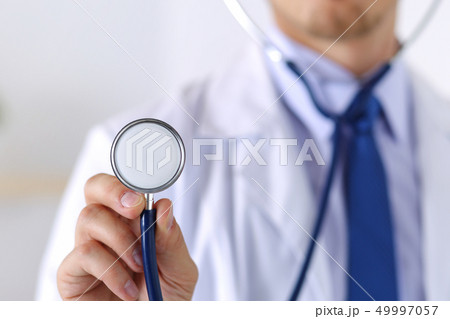Male medicine doctor hand holding stethoscope head Male medicine doctor hand holding stethoscope head 49997057