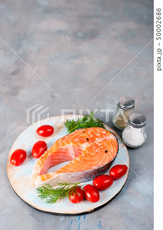 Vertical shot of fresh salmon steak with tomatoes 50002686