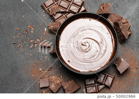 ceramic bowl of chocolate cream or melted chocolate and pieces of chocolate isolated on dark ceramic bowl of chocolate cream or melted chocolate and pieces of chocolate isolated on dark 50002966