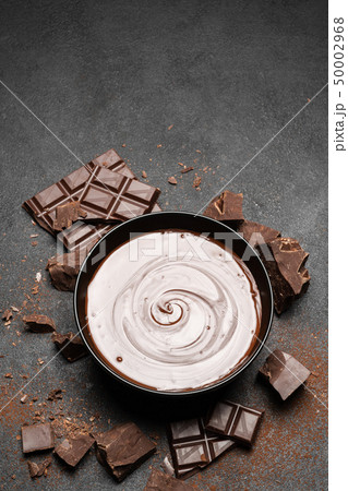 ceramic bowl of chocolate cream or melted chocolate and pieces of chocolate isolated on dark ceramic bowl of chocolate cream or melted chocolate and pieces of chocolate isolated on dark 50002968