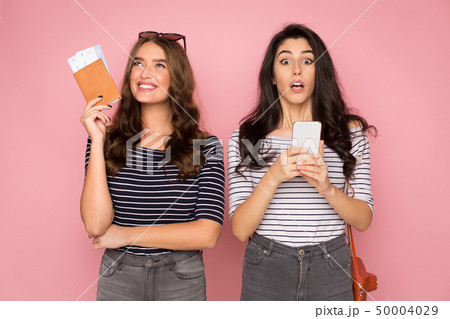 Incredible sale. Women preparing for trip, holding tickets and phone 50004029